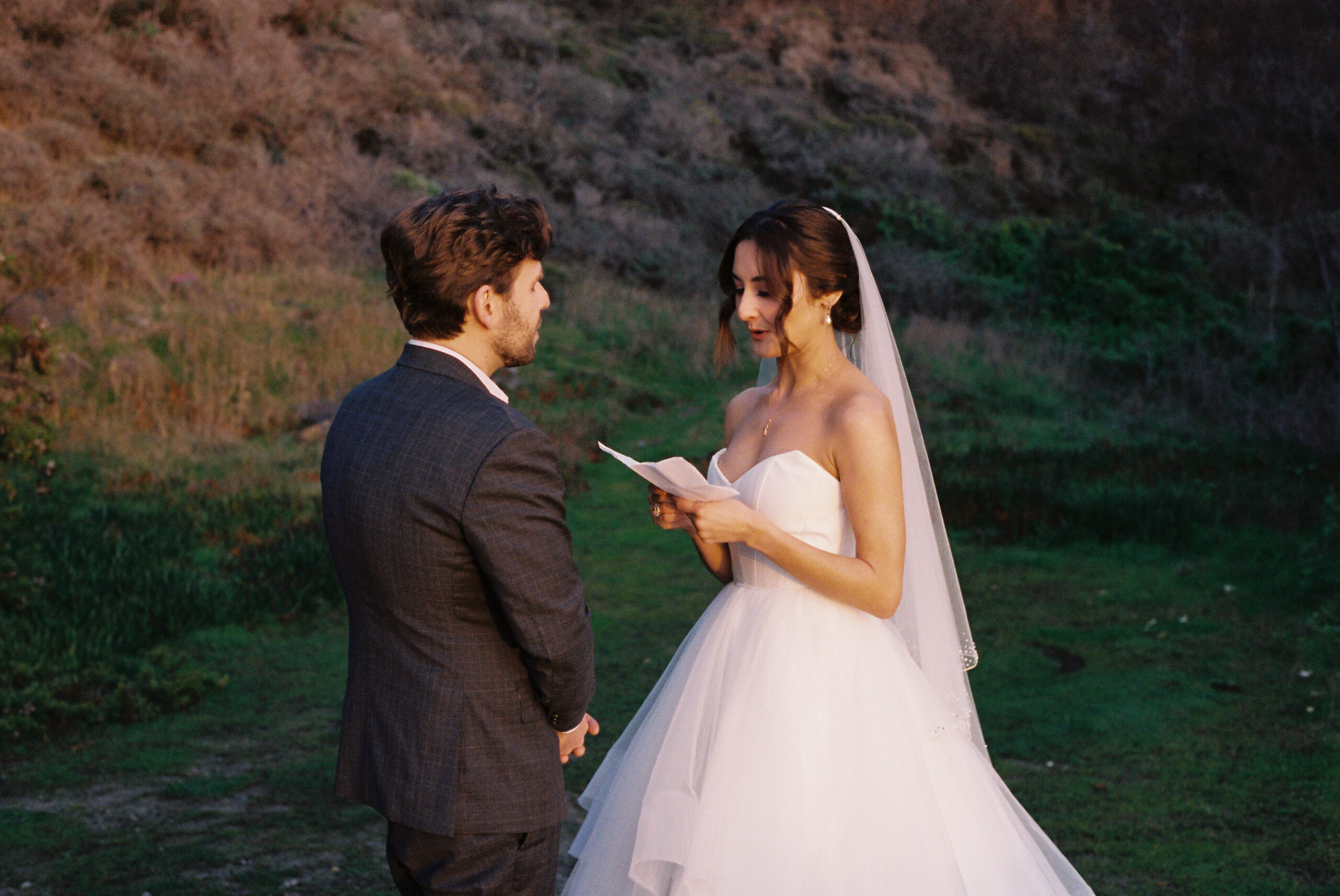authentic film photo of bride and groom reading vows at stinson beach